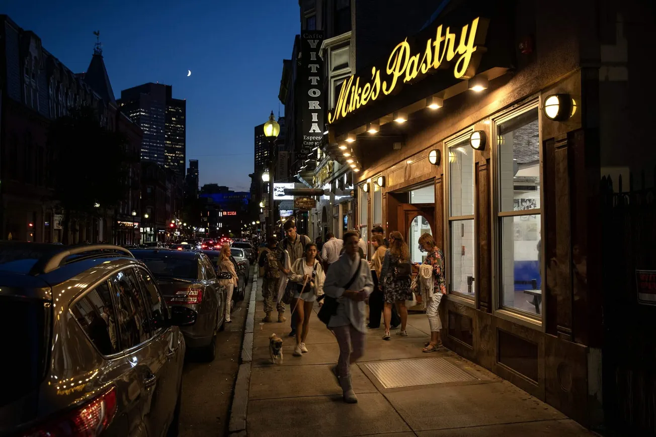 La gente abarrota la acera fuera de Mike's Pastry en Hanover Street, en el North End de Boston. (Robin Lubbock/WBUR)
