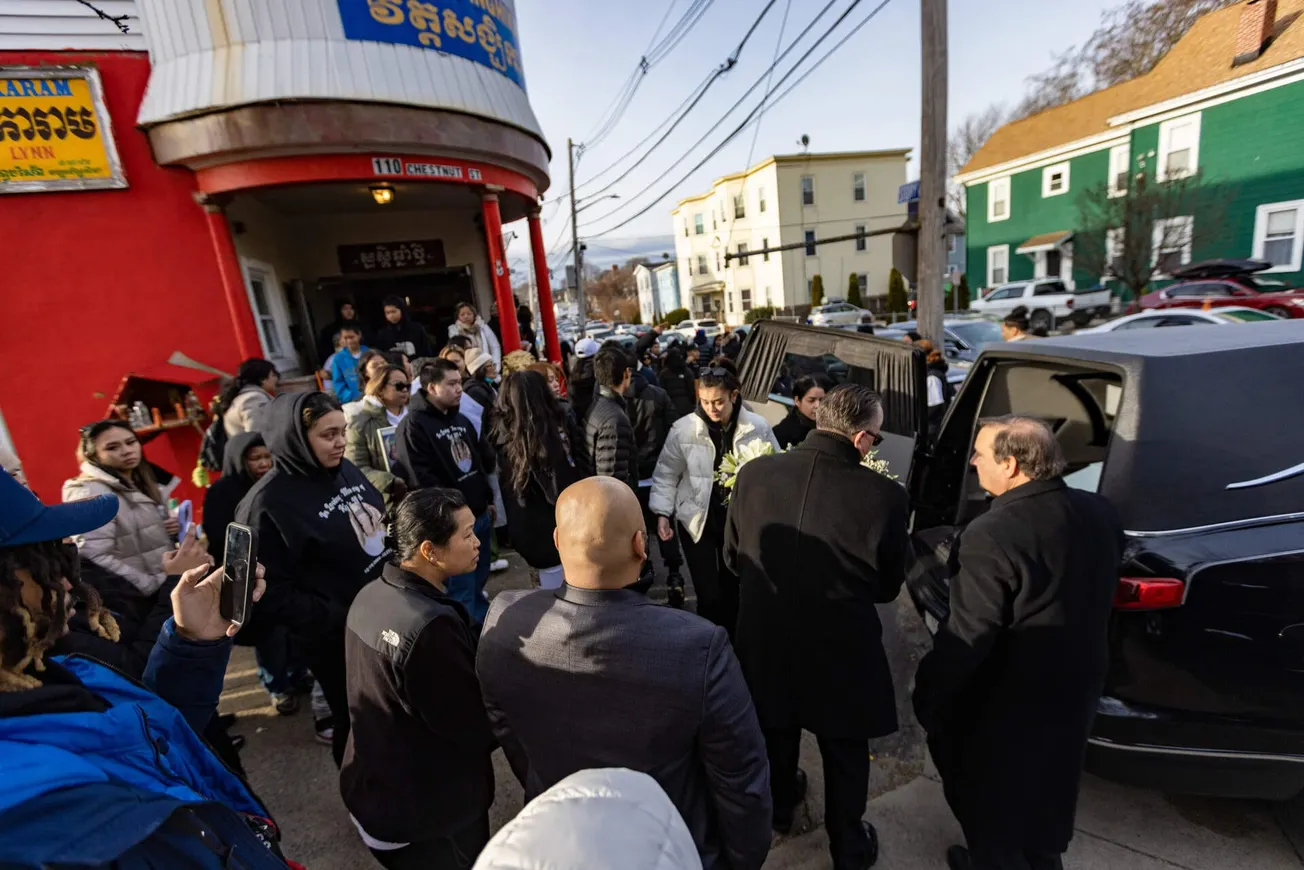 Los dolientes se reúnen afuera de un templo budista en Lynn después de que el ataúd con el cuerpo de Kyle Mel es colocado en