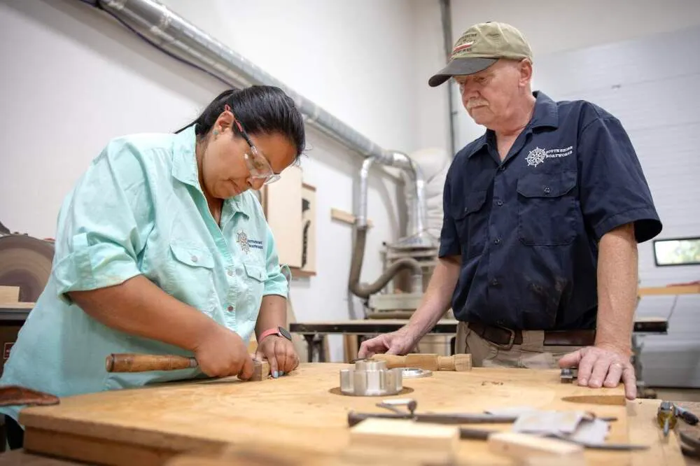 Christina Fuller y su padre Bob trabajan en un banco en su taller en South Shore Boatworks en Carver, Massachusetts. (Robin L