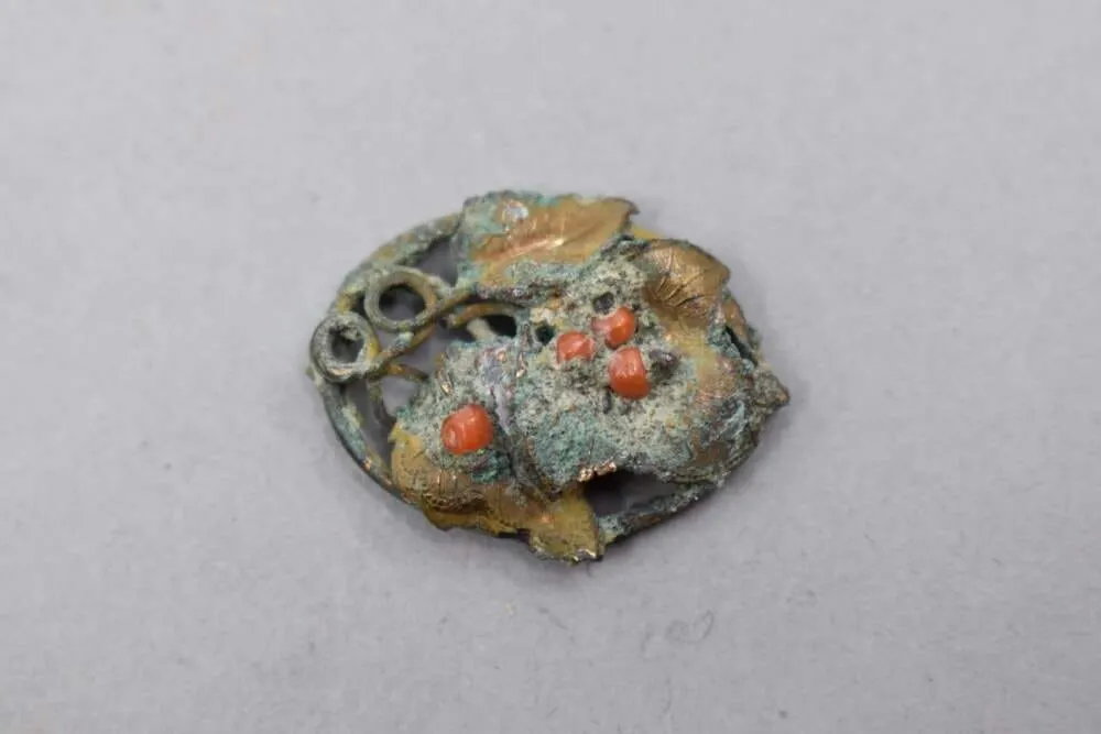 Broche de técnica mixta encontrado en 71 Joy St. en Beacon Hill por arqueólogos de Boston en 2006. (Cortesía del Programa de