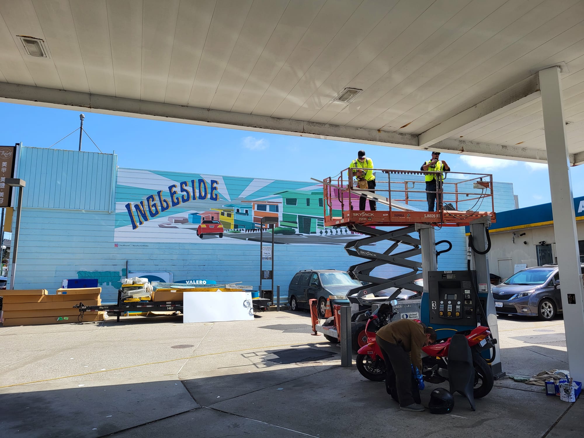 Gas station with workers and a customer.
