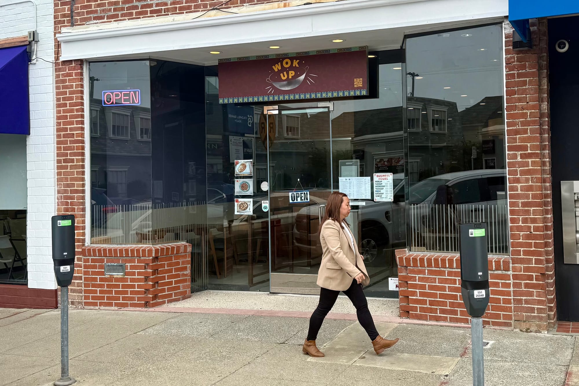 Woman walks in front of a storefront.