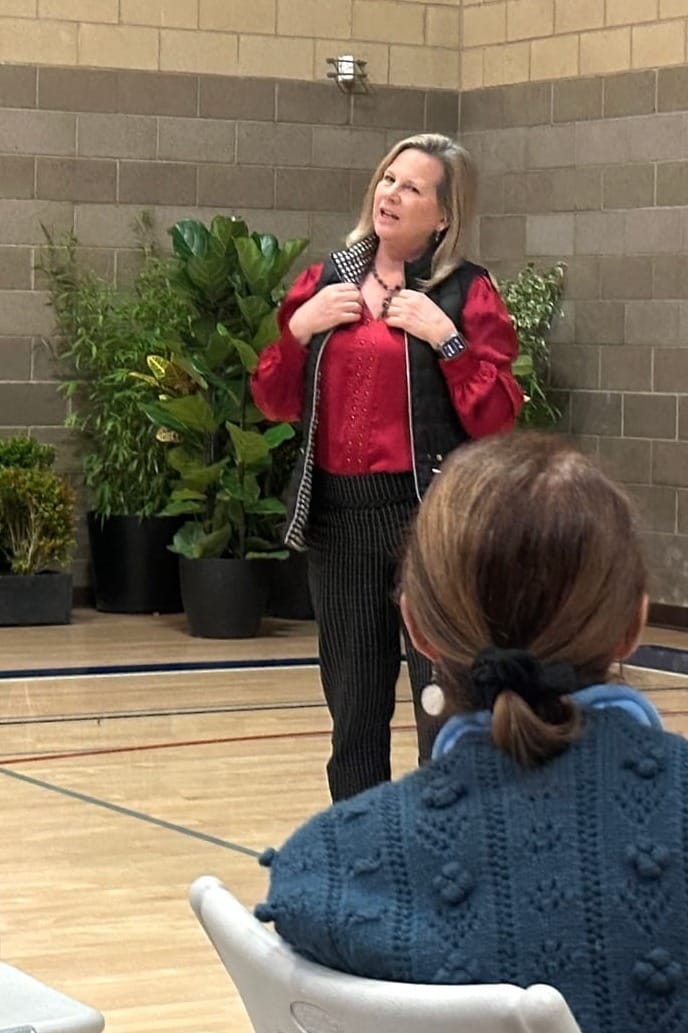 Woman standing and speaking.