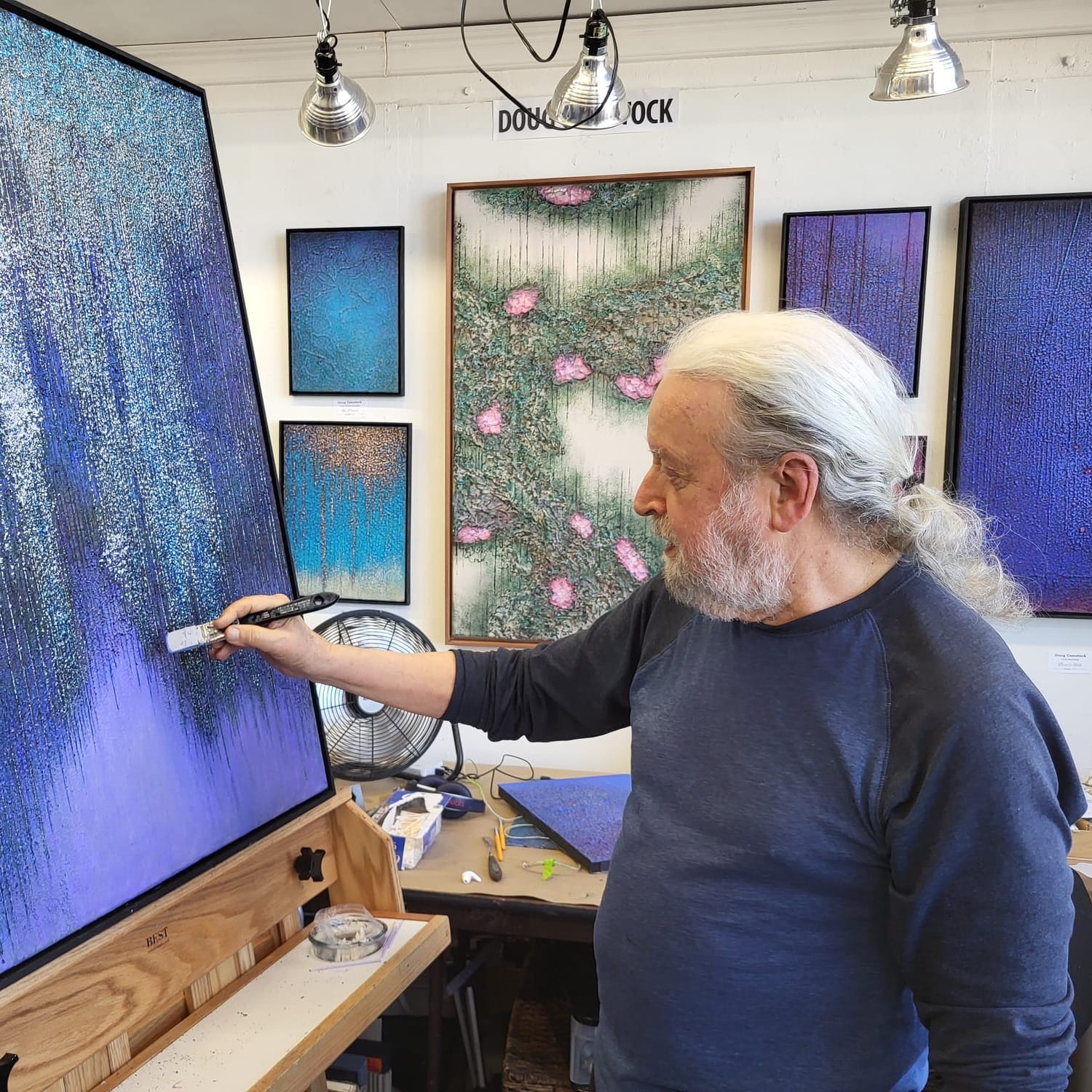 A man painting a blue canvas.