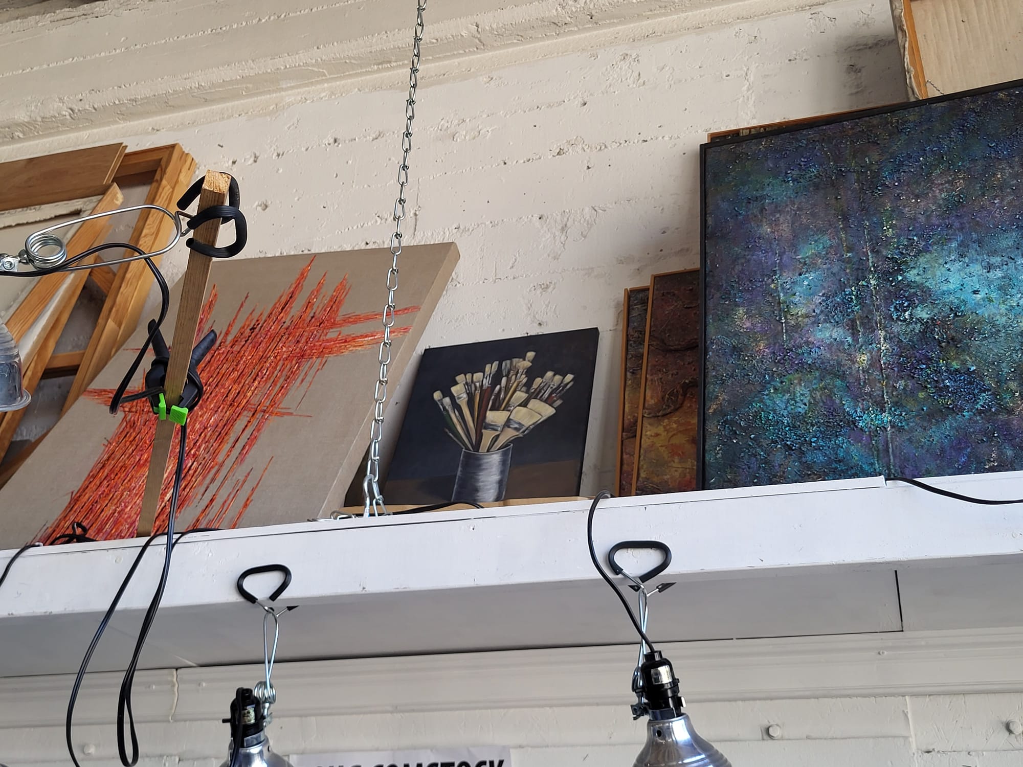Paintings on a shelf.