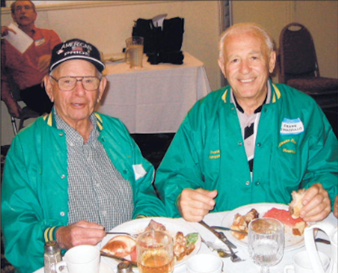 Two men posing for photo at dinner.
