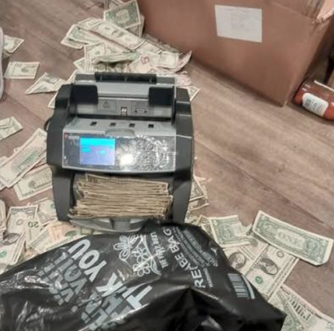 A money counter with bills everywhere.
