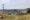 A view of open space in the foreground with homes in the distance.