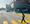 Woman crosses the street in front of a big box store space.