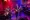 A drummer, two guitarist and an accordion player play behind a red curtain backdrop.