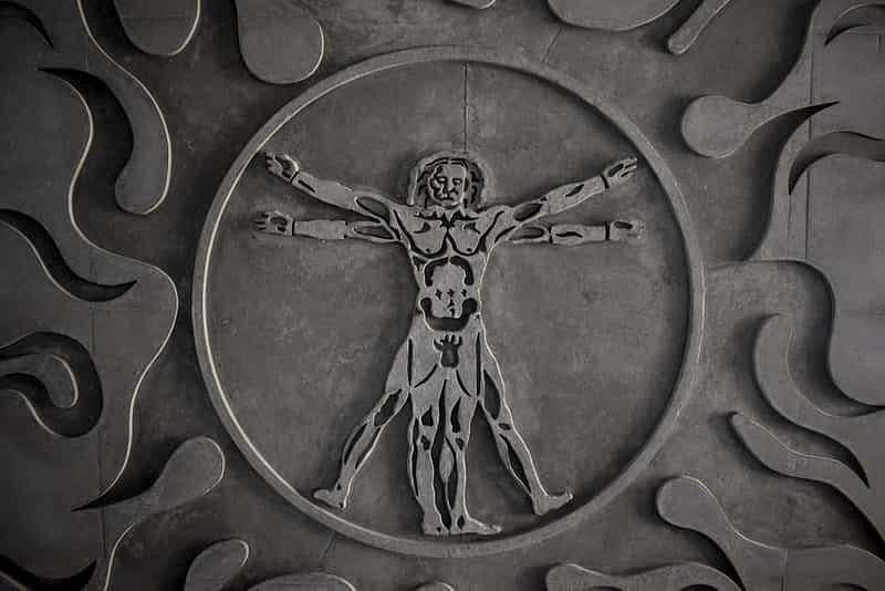 a close-up of a coin depicting an interpretation of Leonardo da Vinci's Vitruvian Man