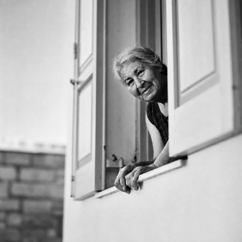 An older woman looking out of a window