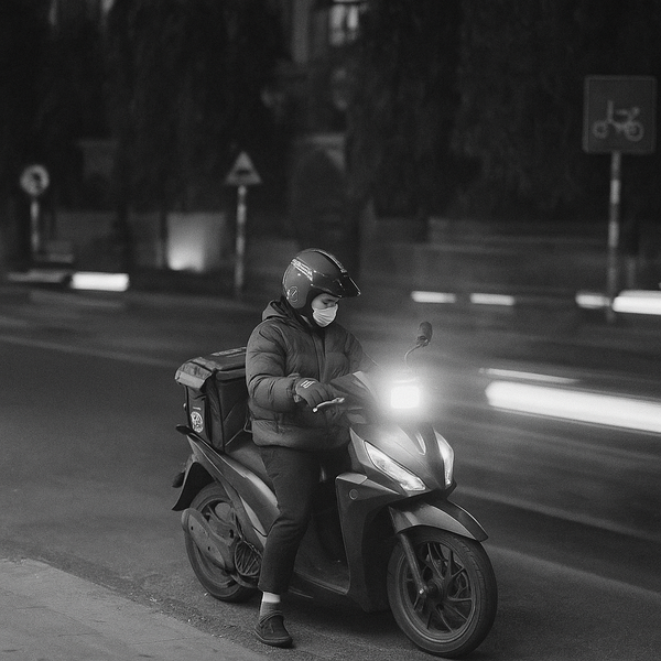 a man riding a motorcycle down a street at night