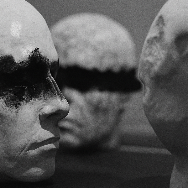 Three ceramic heads with black markings over the eyes