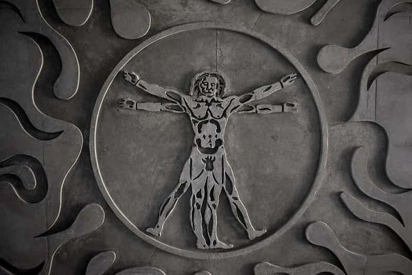 a close-up of a coin depicting an interpretation of Leonardo da Vinci's Vitruvian Man