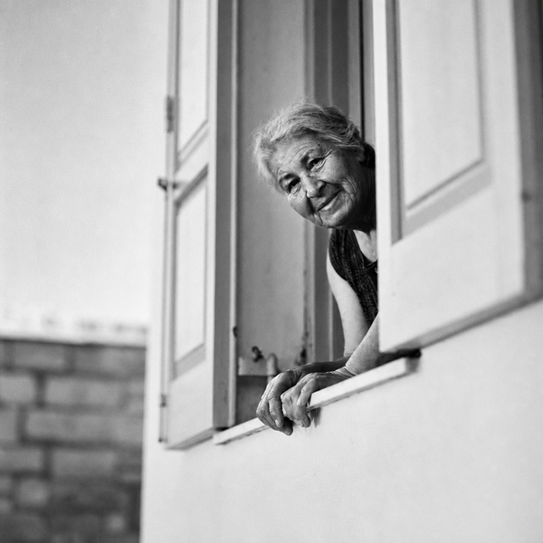 An older woman looking out of a window