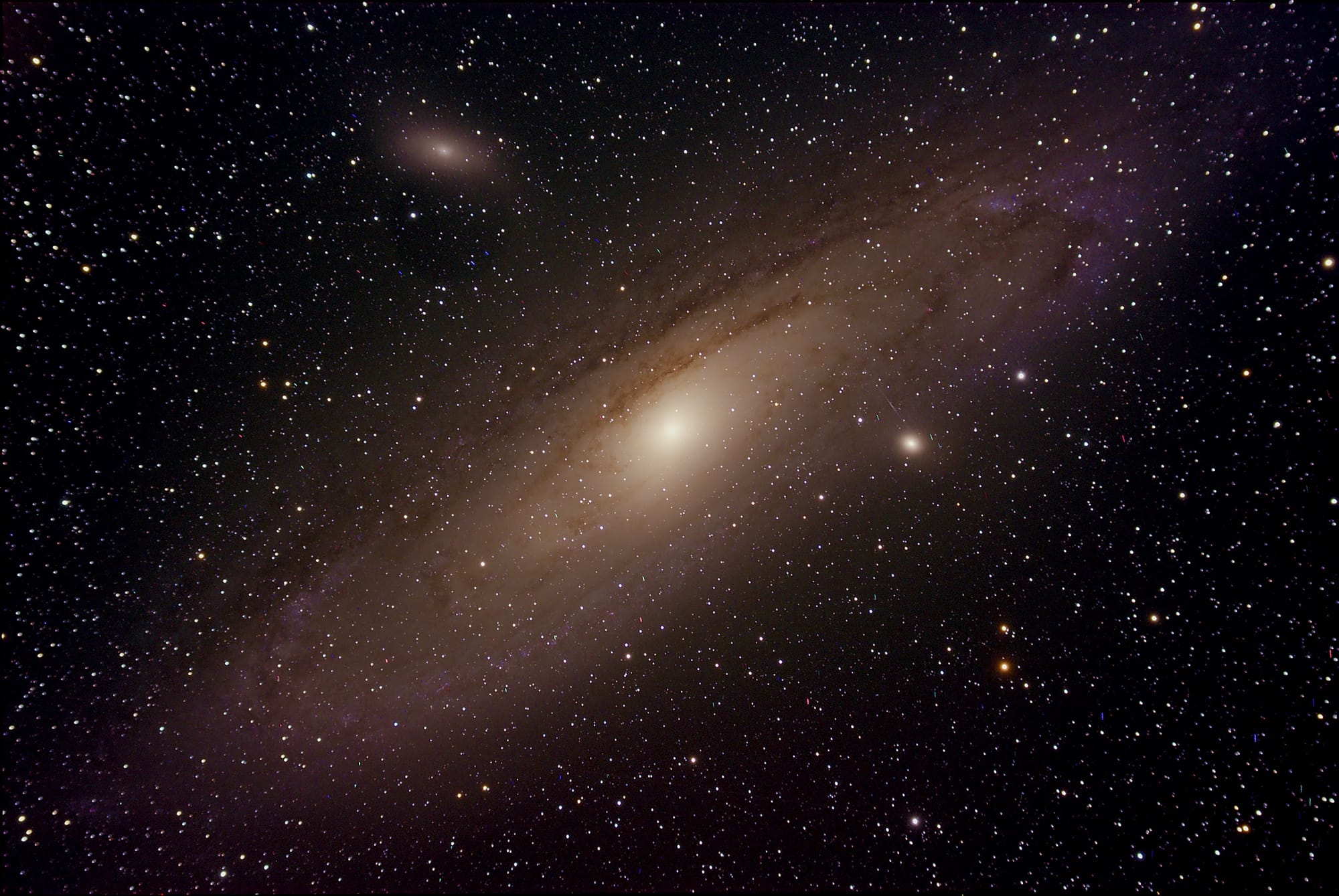 High-resolution image of the Andromeda Galaxy (Messier 31) with visible dust lanes and satellite galaxies M32 and M110, surrounded by a star-filled night sky - foto: Petr Michalík (@michalik_peta)