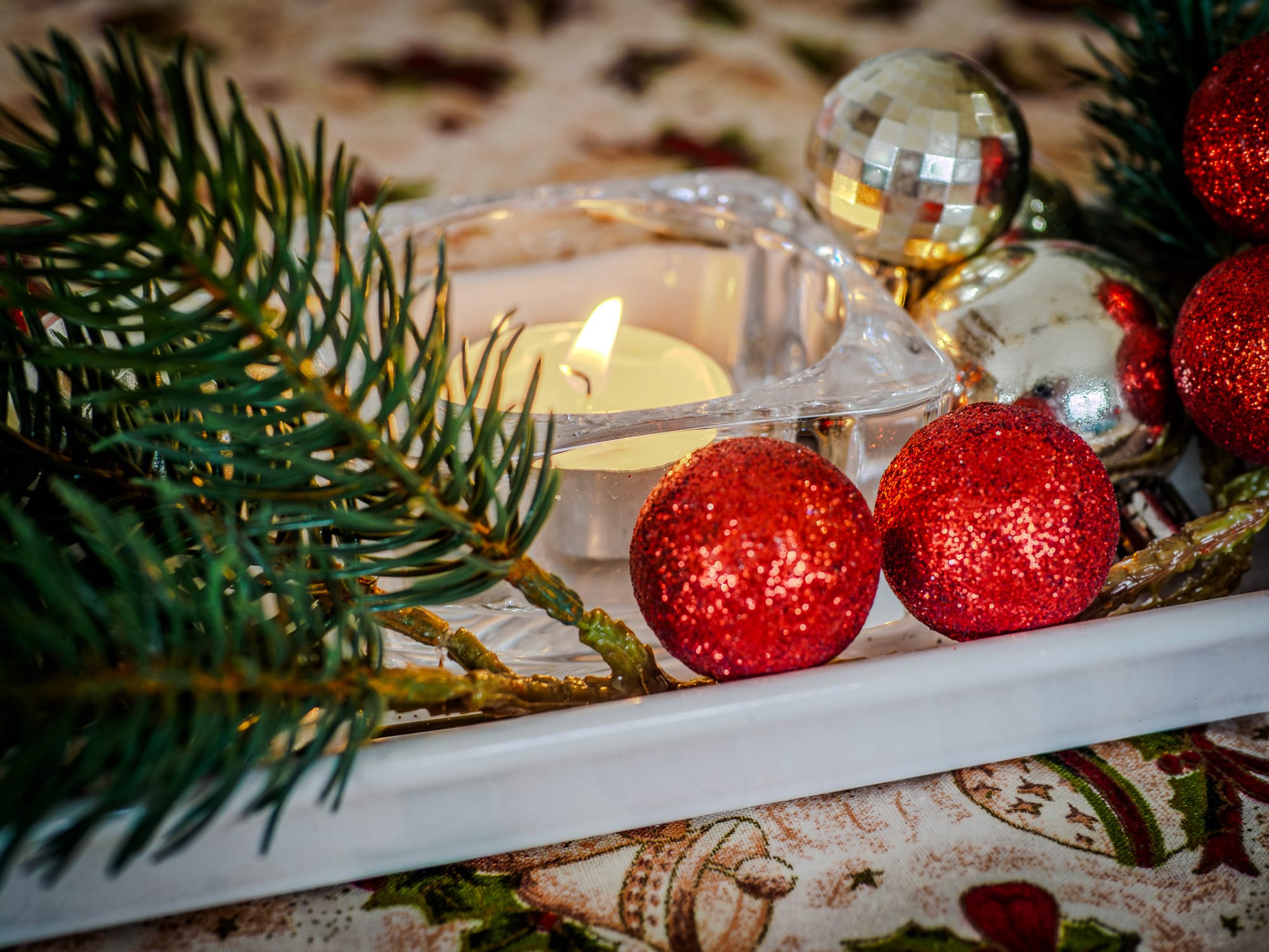HDR merged photograph of a candle surrounded by Christmas decorations, showing balanced highlights and shadows with natural contrast and detail.