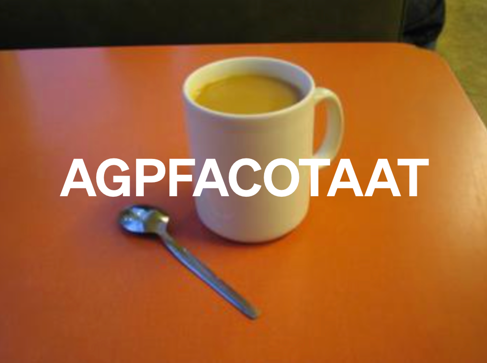 A mug of tea and a tea spoon on a red formica table
