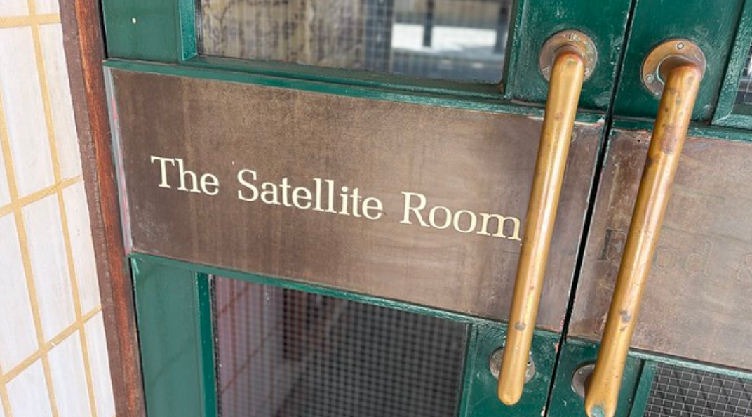 The door to a pub that reads 'The Satellite Room'