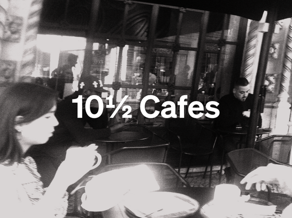 An image of two people in a cafe, one in the foreground, one in the background, with the words 10 1/2 cafes written on top.