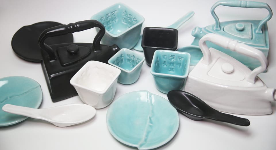 Black, white, and blue porcelain tea cups, soup spoons, plates, and tea pots