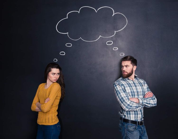 A confused couple facing away from each other but looking at each other.