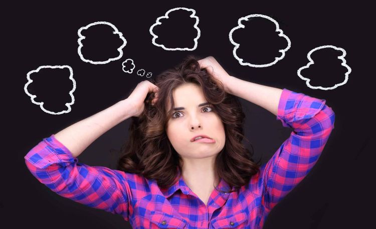 A frustrated woman has her hands in her hair and five call-out bubbles are above her.