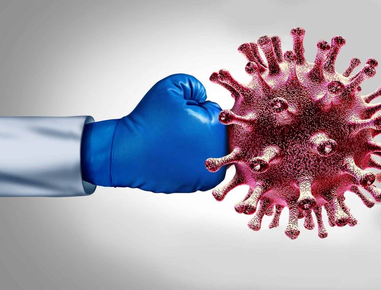 An arm with a blue boxing glove is punching a red virus.