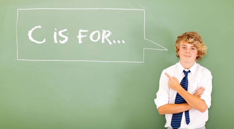 A boy with blonde hair is pointing to the callout that says, "C is for..."