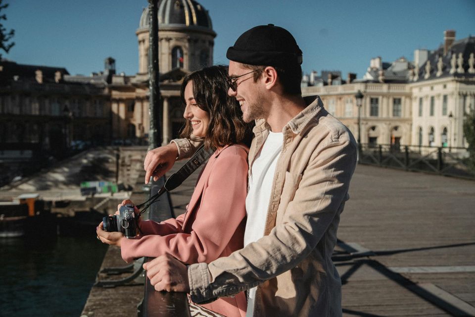 A dating couple is traveling together in Europe and the woman is holding a camera. 