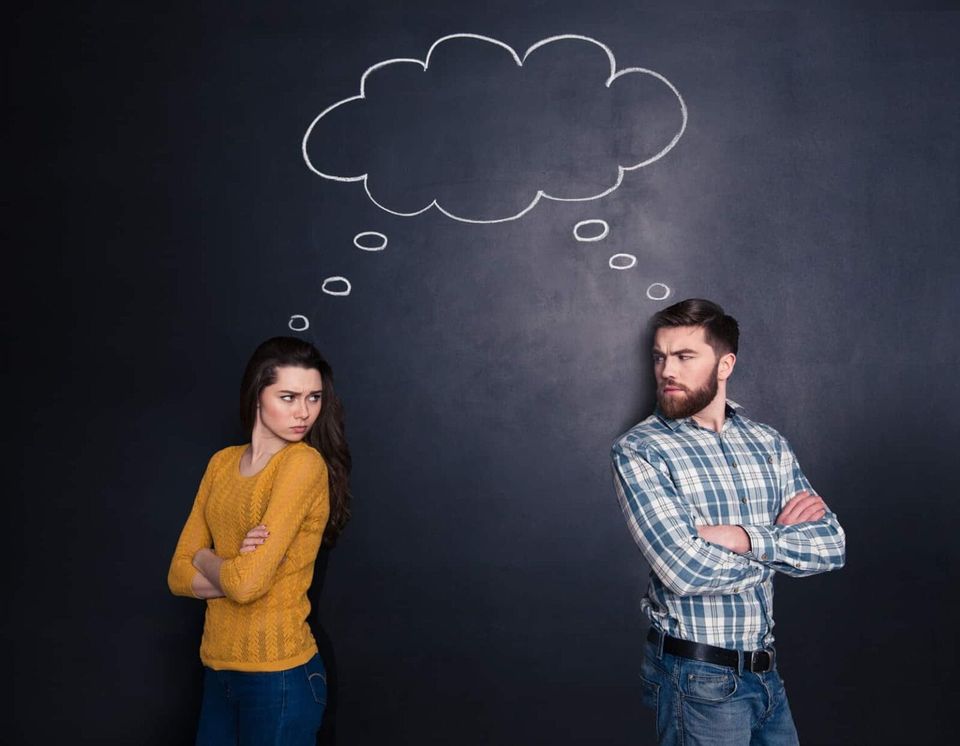 A confused couple facing away from each other but looking at each other.