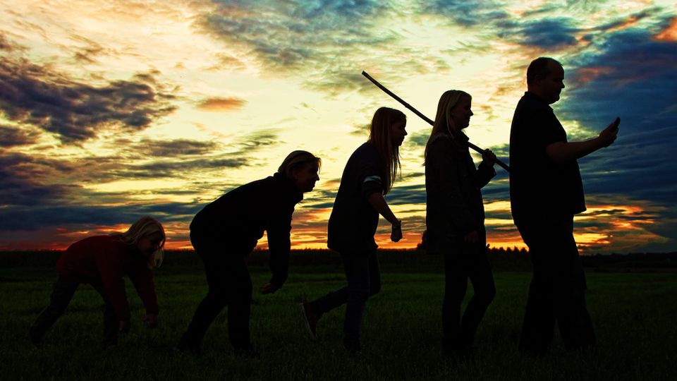 An picture of an evolutional process at sunset. A man is hunched over then stands up.