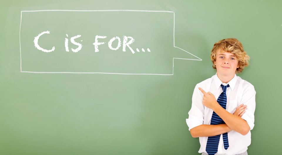 A boy with blonde hair is pointing to the callout that says, "C is for..."