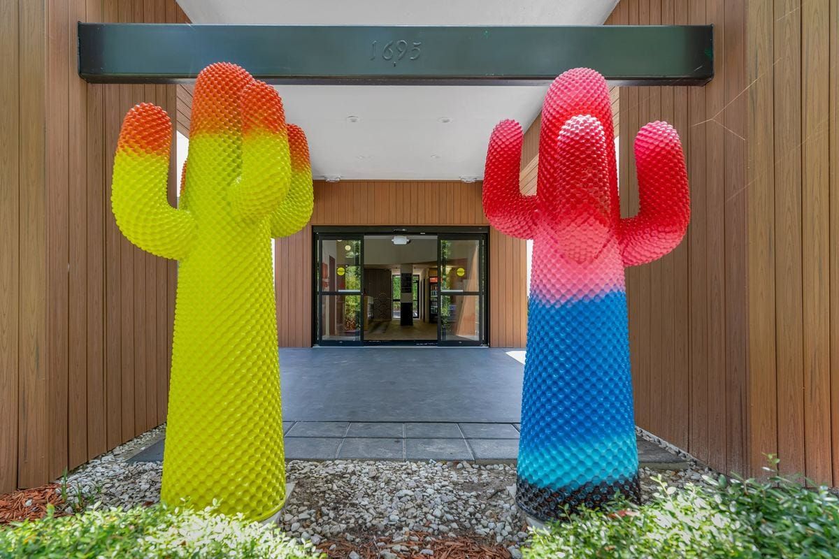 Two giant cactus sculptures, one yellow and one rainbow, at BOB's entrance