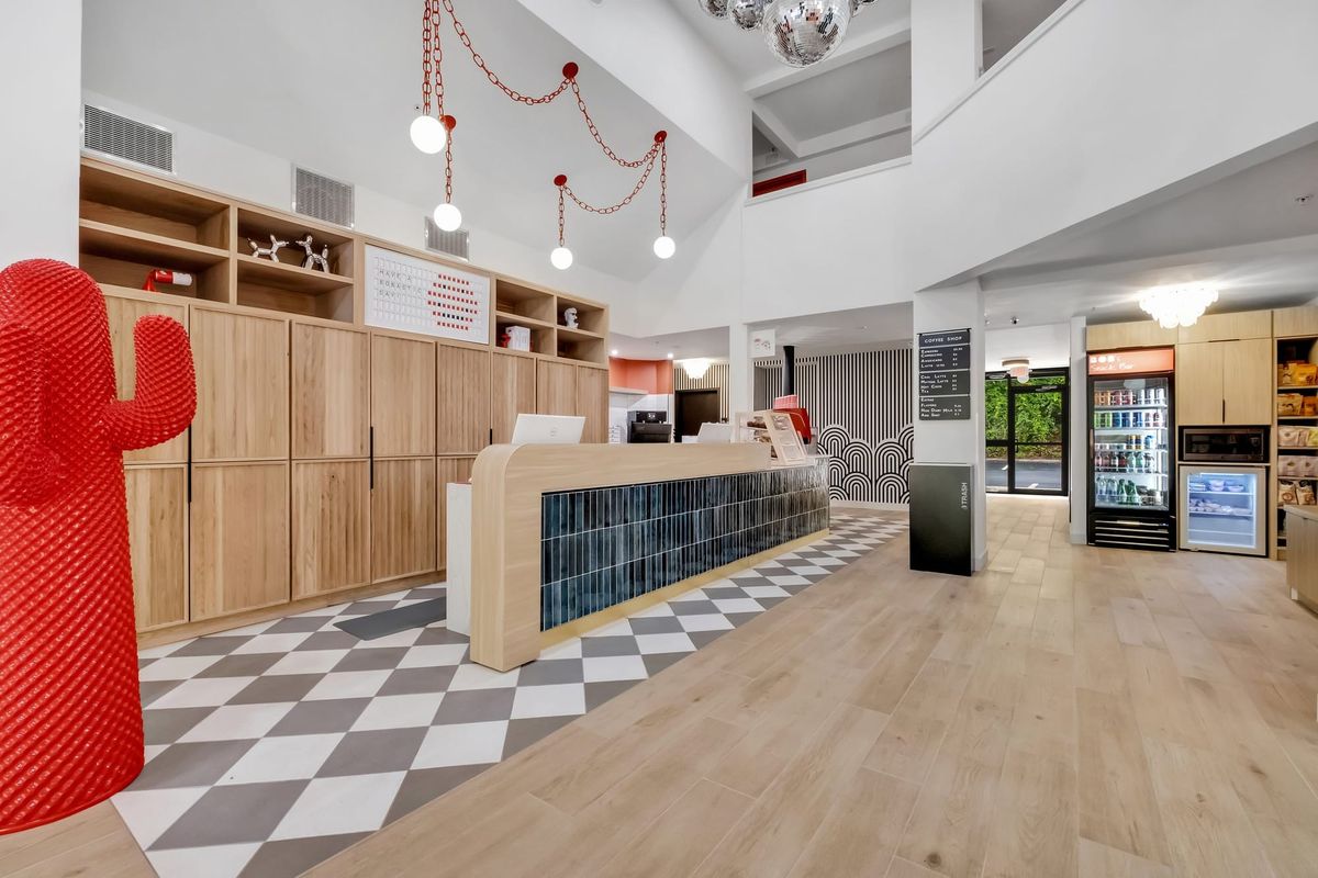 BOB's bright double-height lobby with a red cactus, the tiled front desk, disco balls and the coffee shop