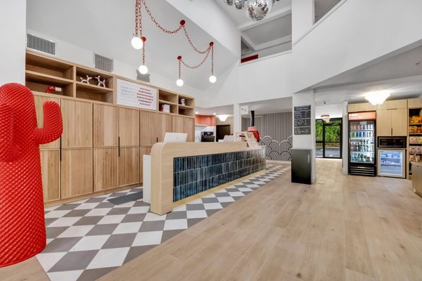 BOB's bright double-height lobby with a red cactus, the tiled front desk, disco balls and the coffee shop