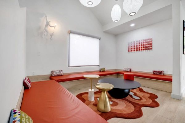 A sunlit BOB lounge corner with red cushions and a gold side table
