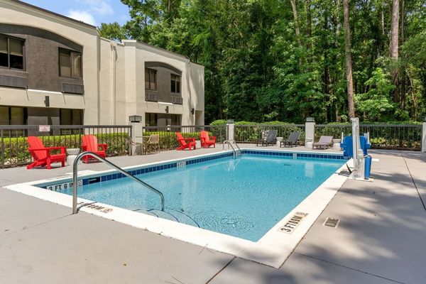 BOB's outdoor pool with red Adirondack chairs under tall pines