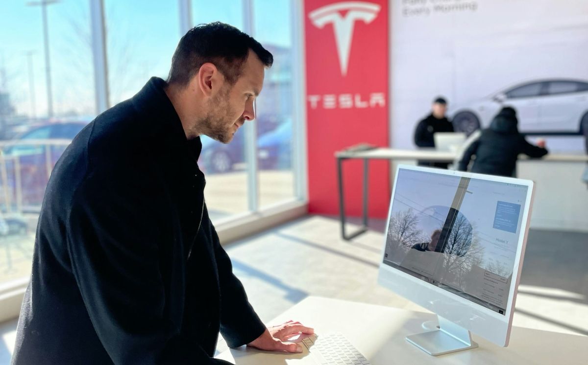 Man searching for used teslas at a tesla location