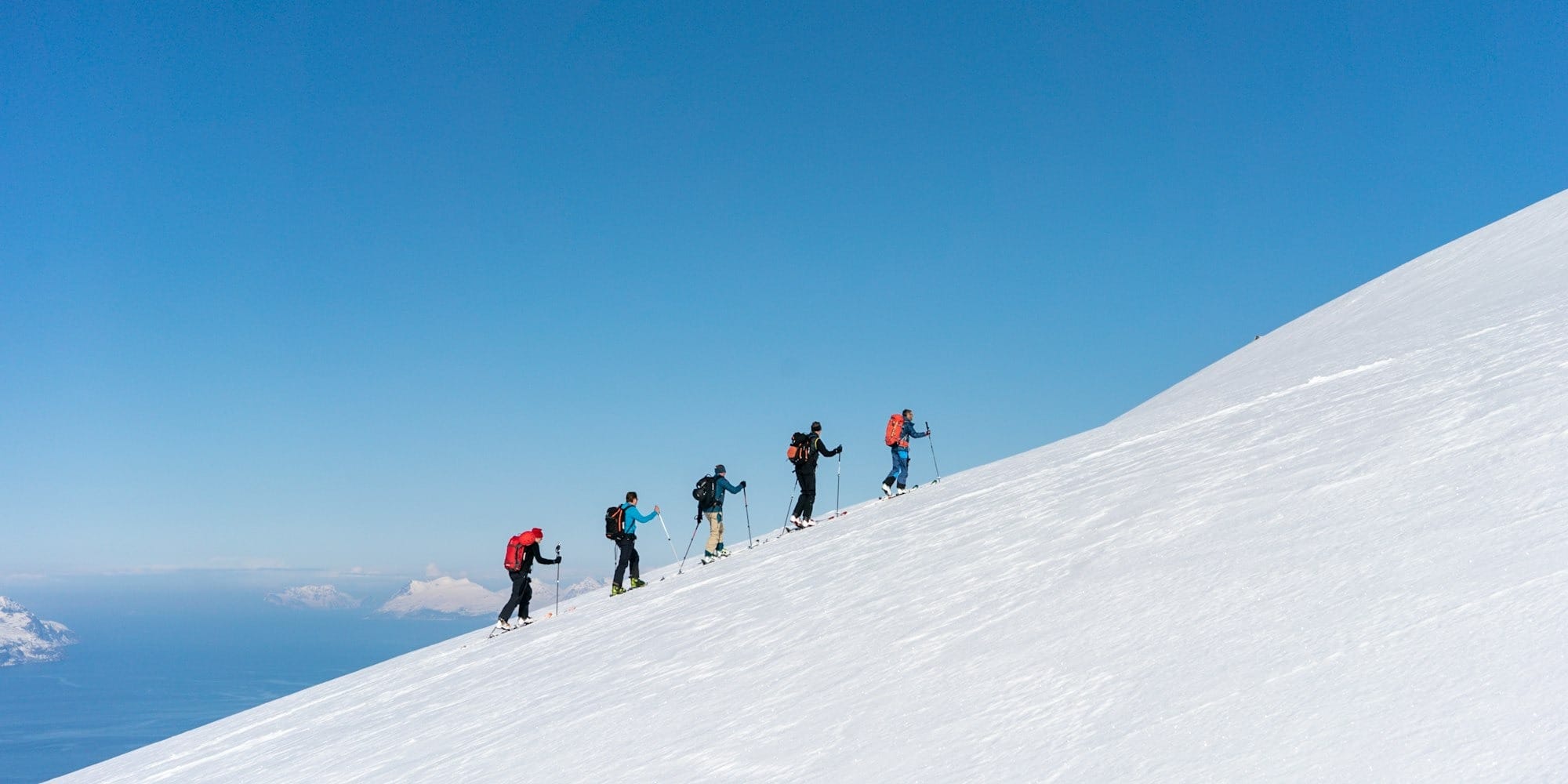 a group of people riding skis on top of a snow covered slope