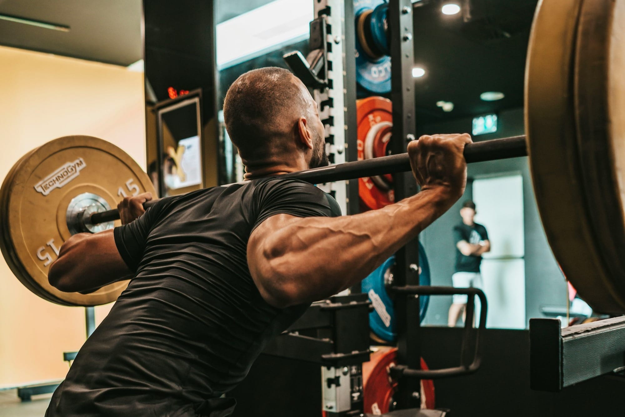 a man doing squats with a barbell in a gym