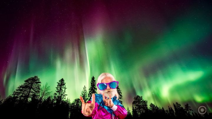 weirdly dressed party man with northern lights behind him