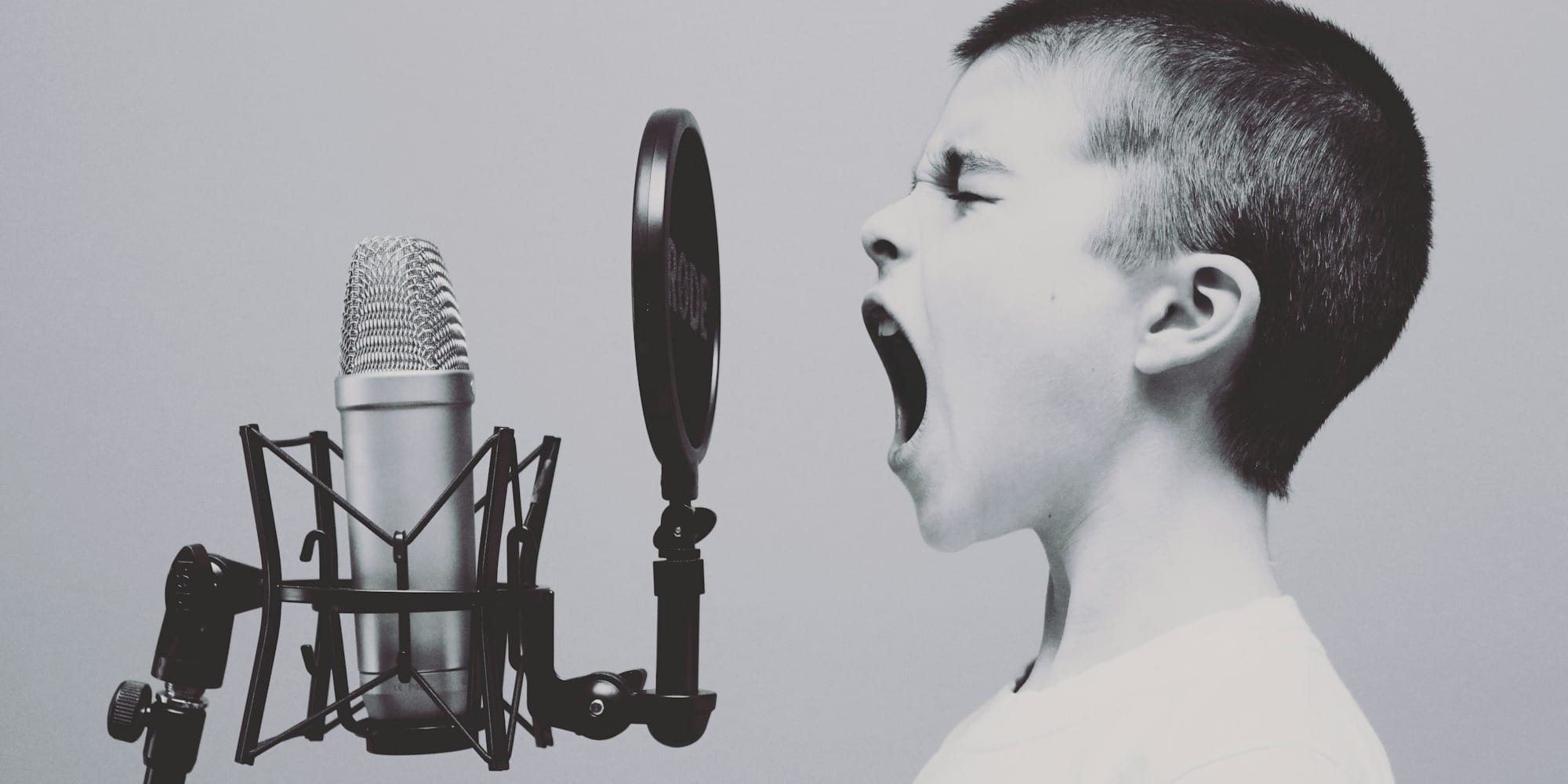 boy singing on microphone with pop filter