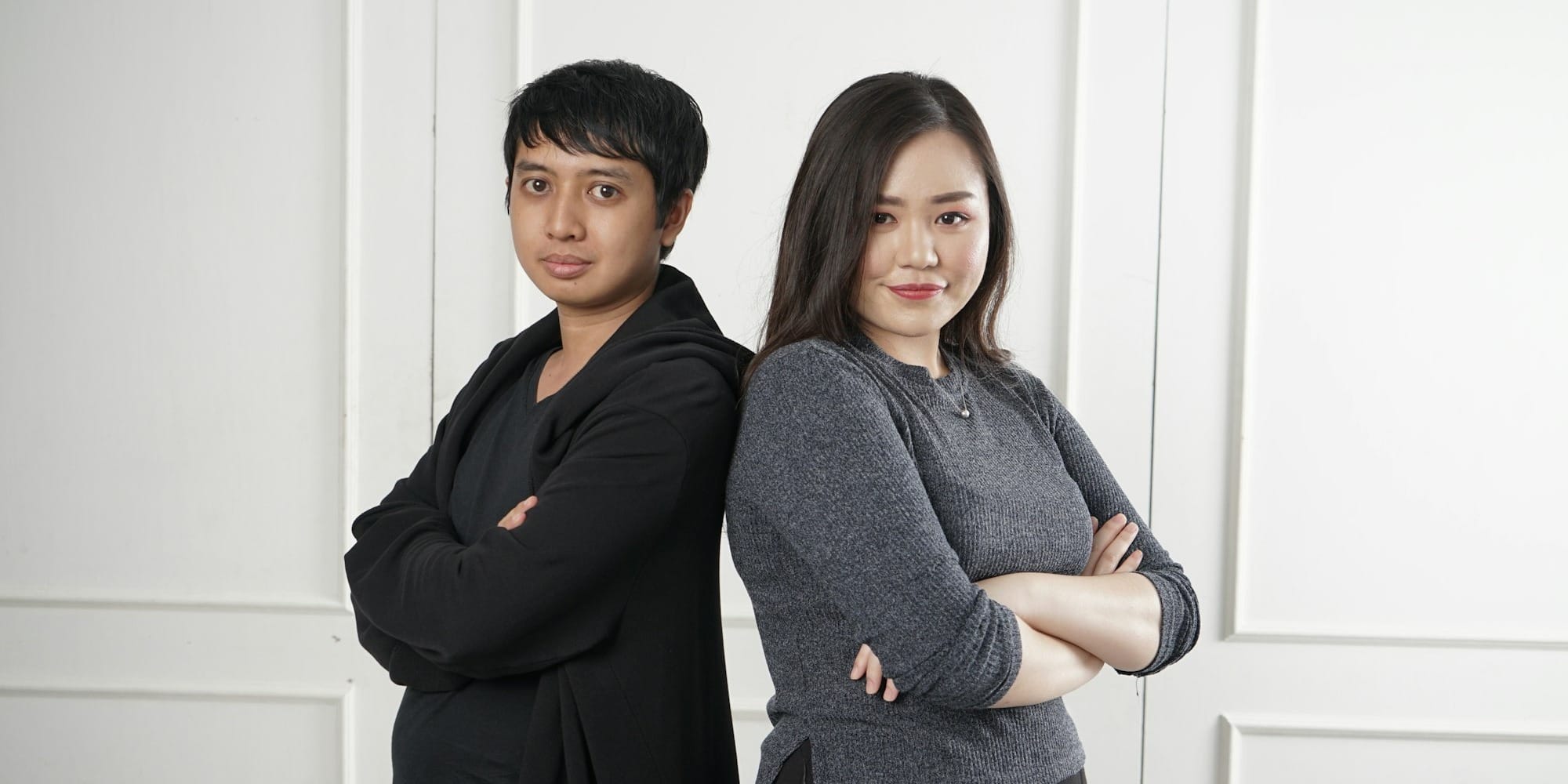 two women standing near white wall
