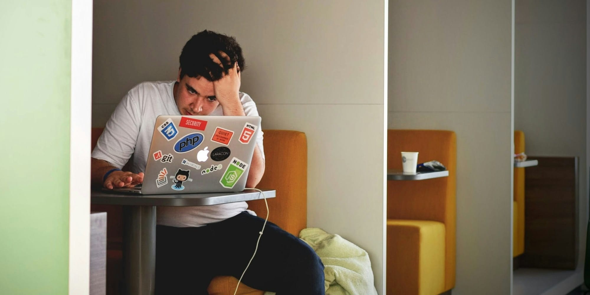 man wearing white top using MacBook