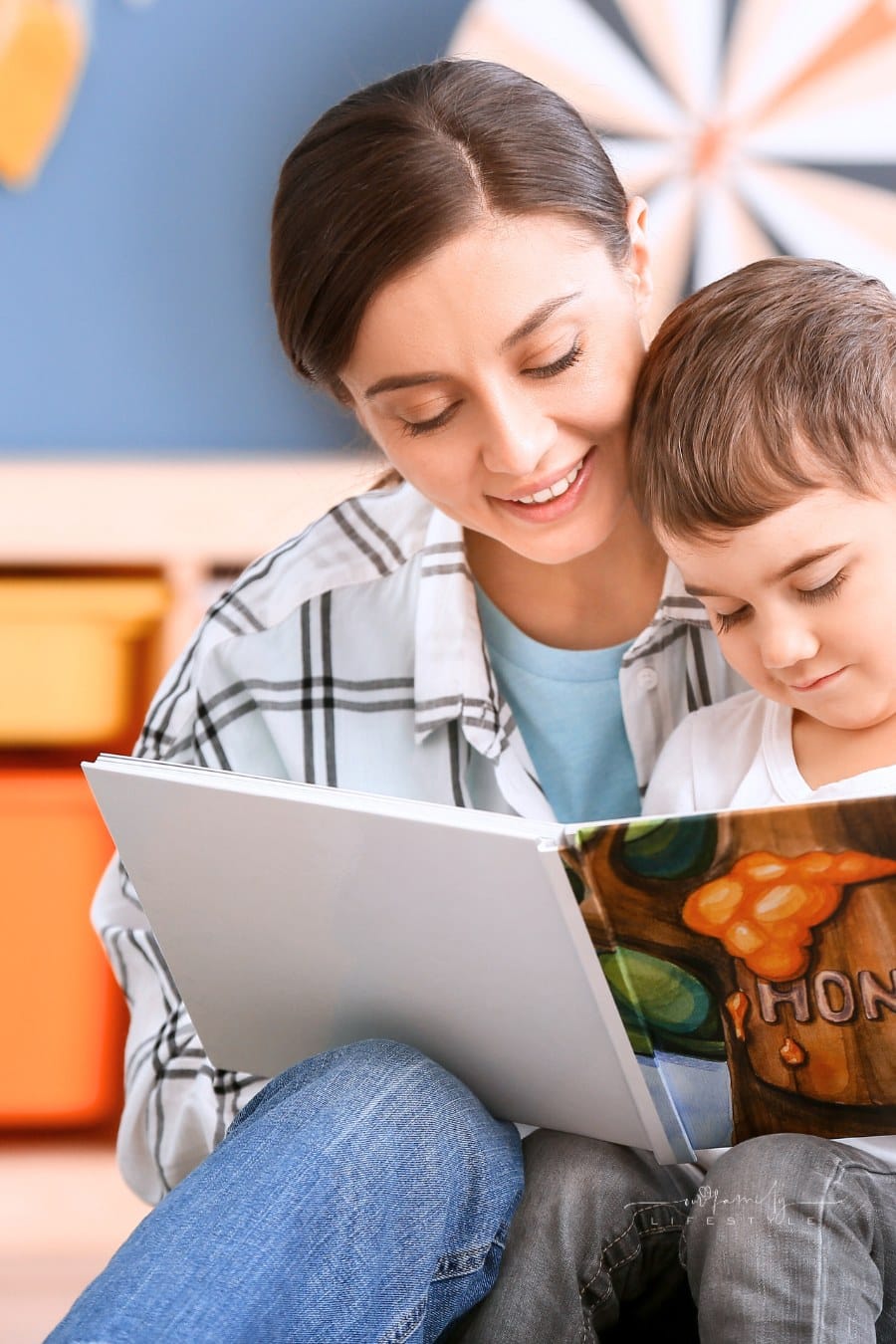 Nanny and Cute Little Boy Reading Book at Home