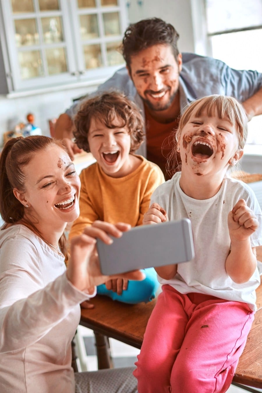 family taking a selfie in the kitchen with chocolate covered faces