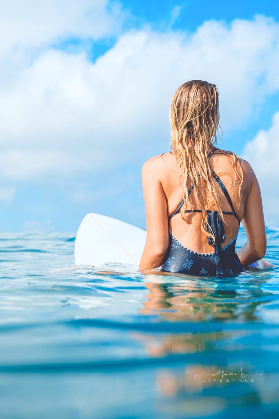 Surfer woman in swimwear with surfboard. Woman with surfboard in tropical ocean.