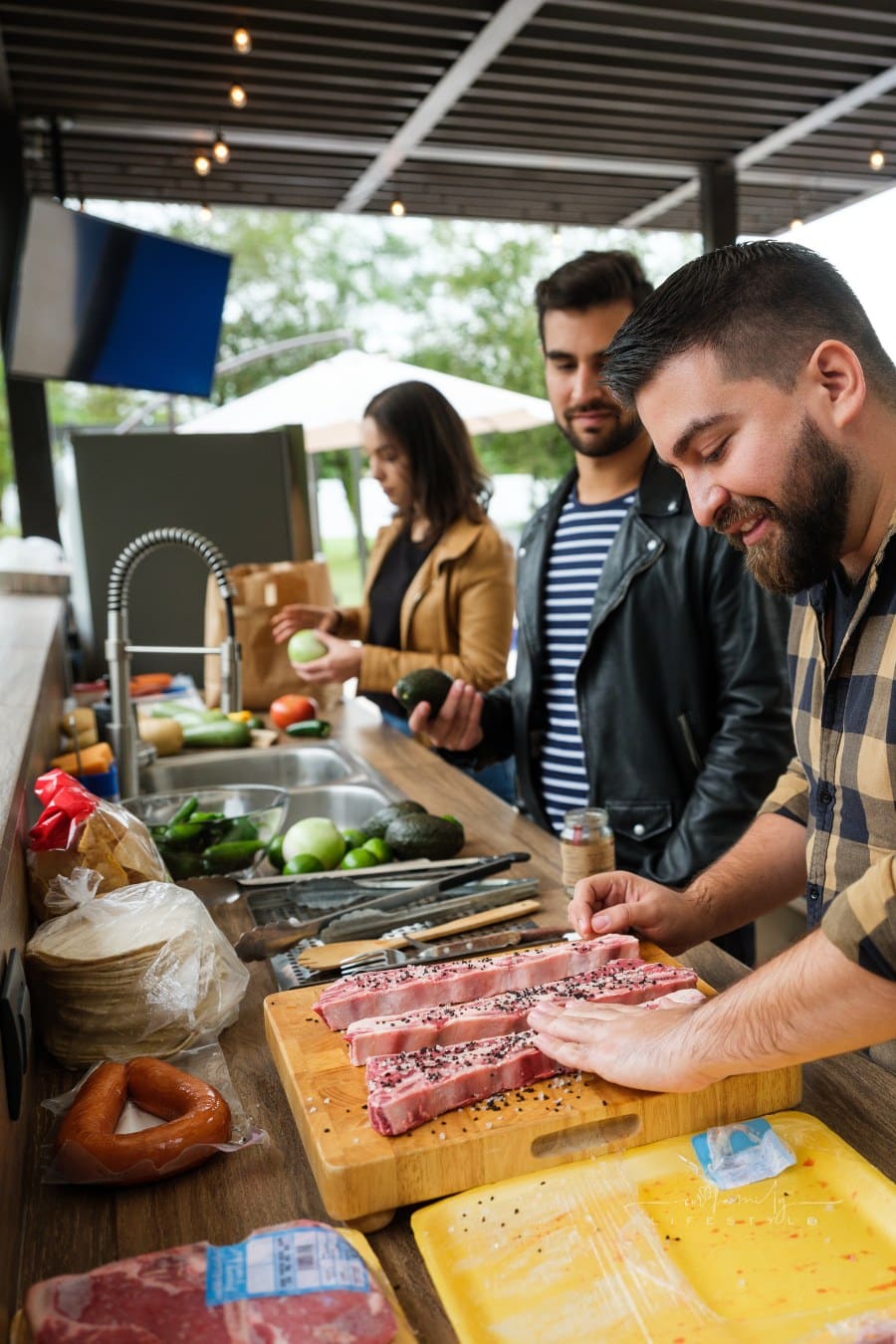 Friends cooking together in outdoor kitchen